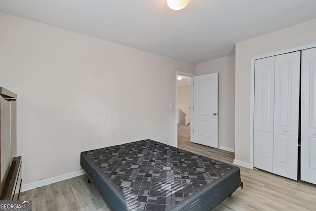 bedroom with a closet and light hardwood / wood-style flooring