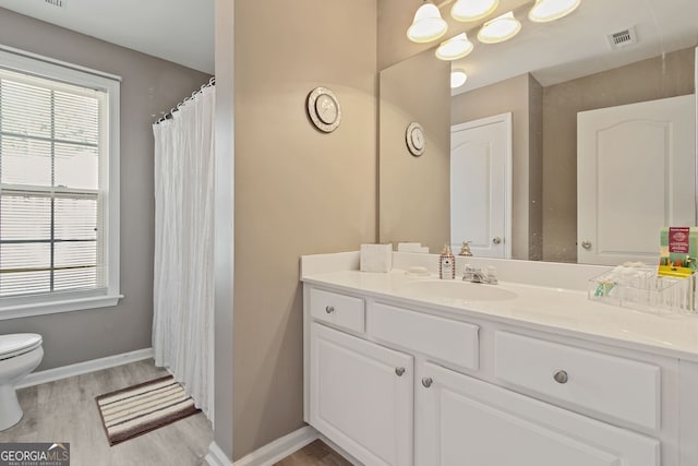 bathroom featuring hardwood / wood-style flooring, vanity, and toilet