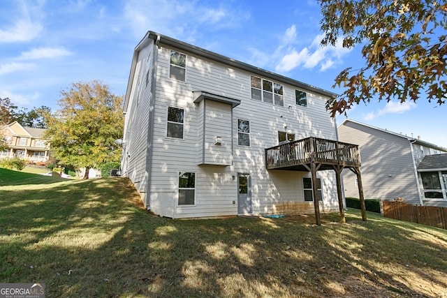 rear view of house with a yard and a deck