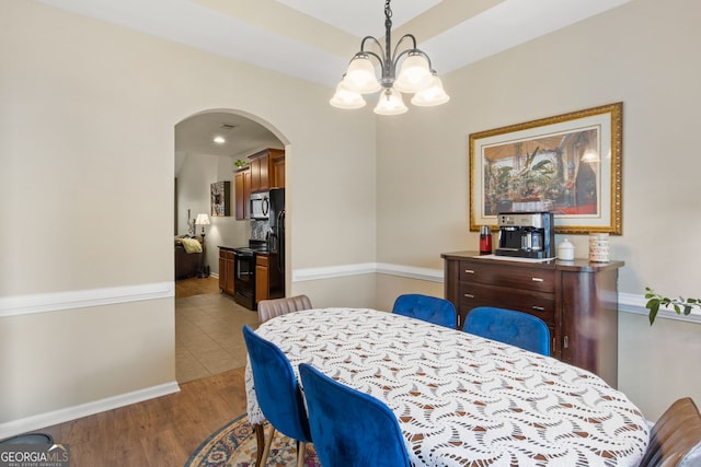 dining room featuring light wood-type flooring and a chandelier