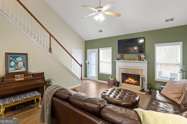 living room featuring hardwood / wood-style flooring, ceiling fan, and lofted ceiling