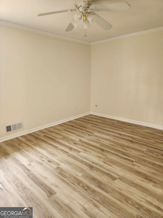 empty room featuring ceiling fan, hardwood / wood-style floors, and ornamental molding