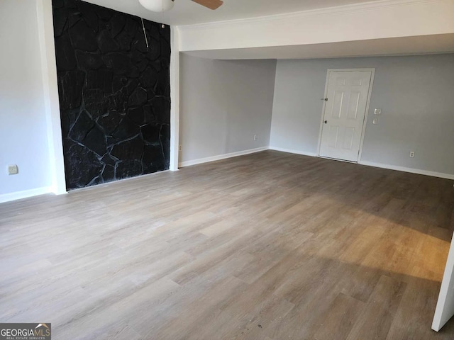 spare room featuring light wood-type flooring, ceiling fan, and crown molding