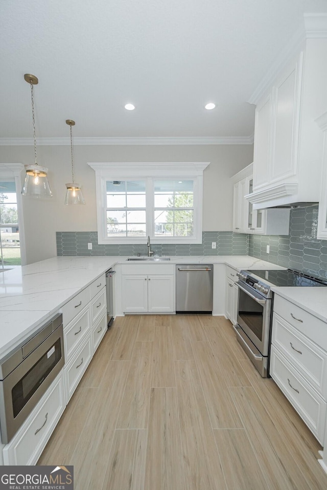 kitchen featuring a healthy amount of sunlight, sink, white cabinetry, and stainless steel appliances