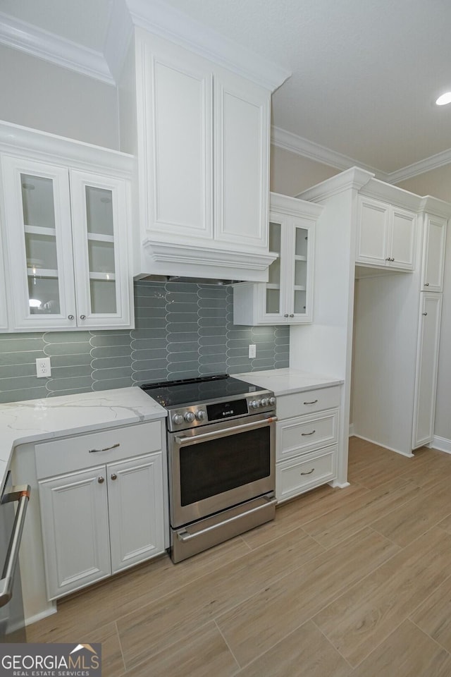 kitchen featuring white cabinets, stainless steel range oven, and light hardwood / wood-style flooring