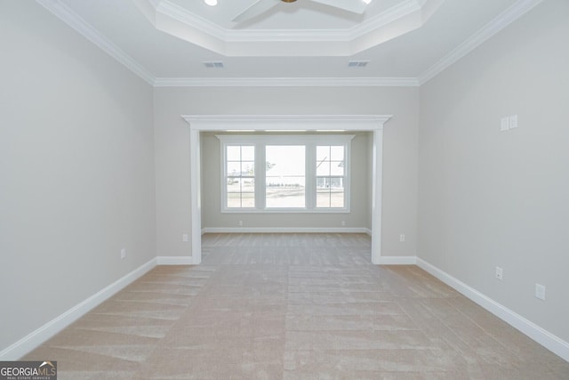 unfurnished room featuring ceiling fan, a raised ceiling, and crown molding