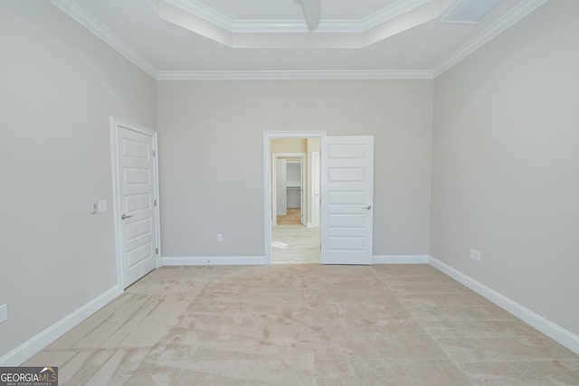 carpeted empty room with a tray ceiling and ornamental molding