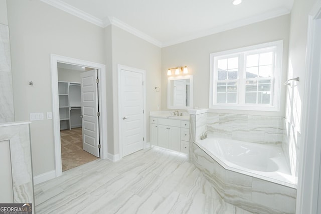 bathroom with tiled tub, vanity, and ornamental molding