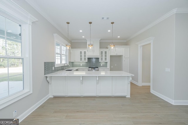 kitchen with decorative light fixtures, white cabinetry, plenty of natural light, and sink