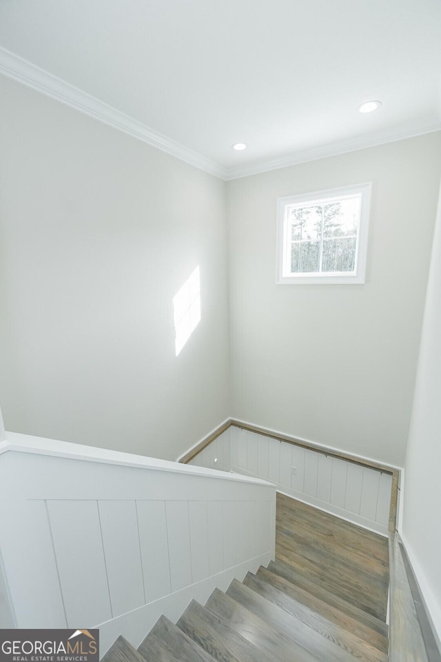 stairway with hardwood / wood-style floors and ornamental molding