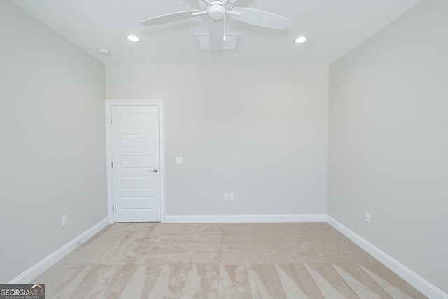 spare room with ceiling fan and light colored carpet