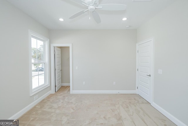 carpeted spare room featuring ceiling fan