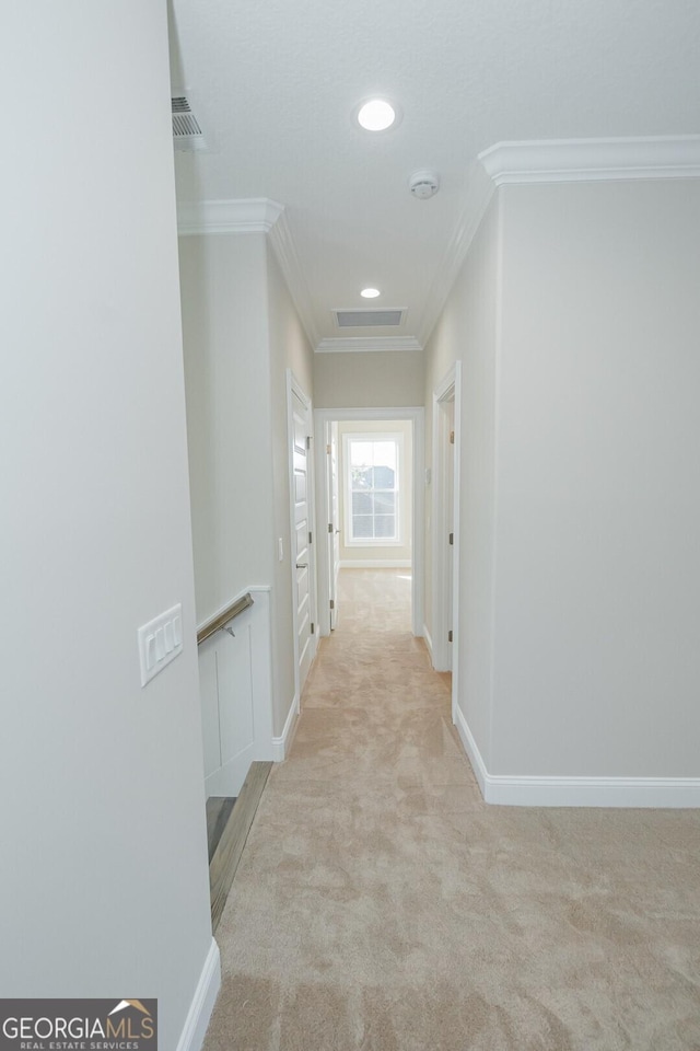 corridor featuring light colored carpet and ornamental molding