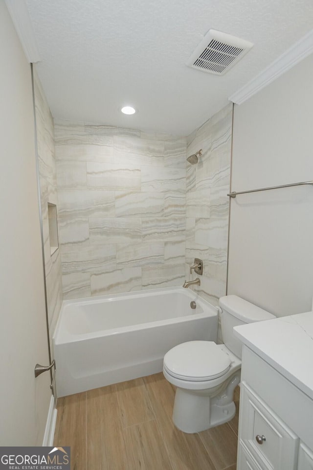 full bathroom with vanity, tiled shower / bath combo, a textured ceiling, wood-type flooring, and toilet