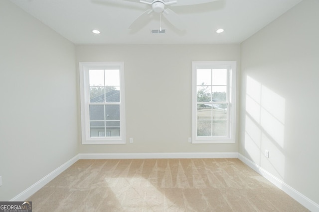 carpeted empty room featuring a wealth of natural light and ceiling fan