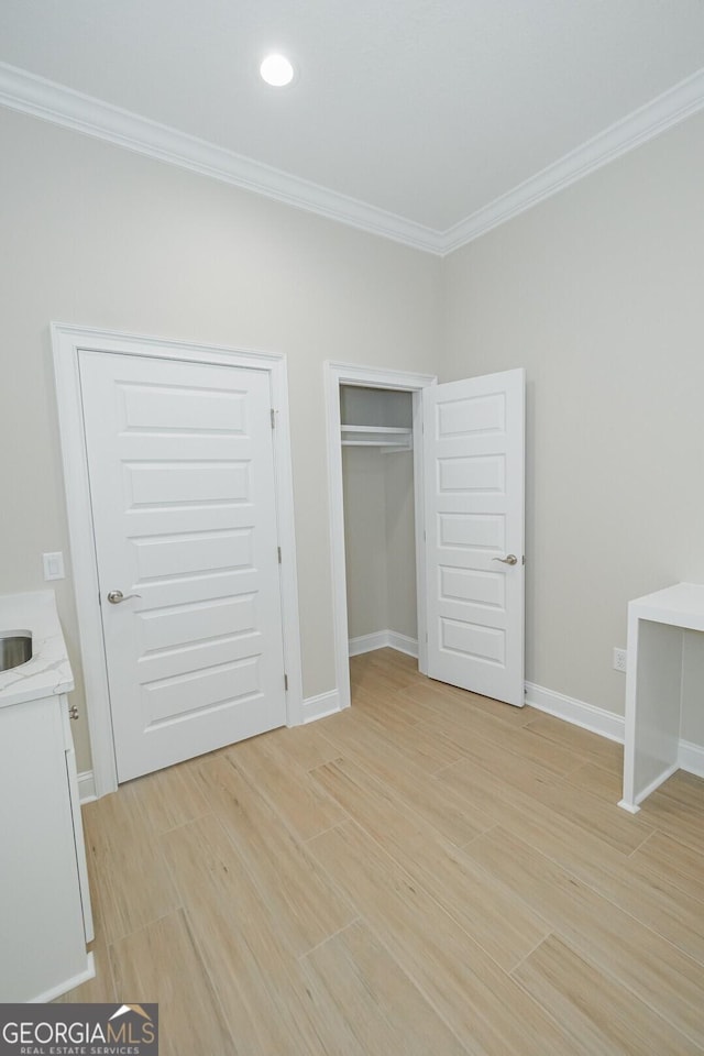 unfurnished bedroom featuring light hardwood / wood-style flooring and ornamental molding