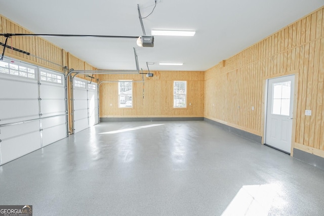 garage with a garage door opener and wooden walls