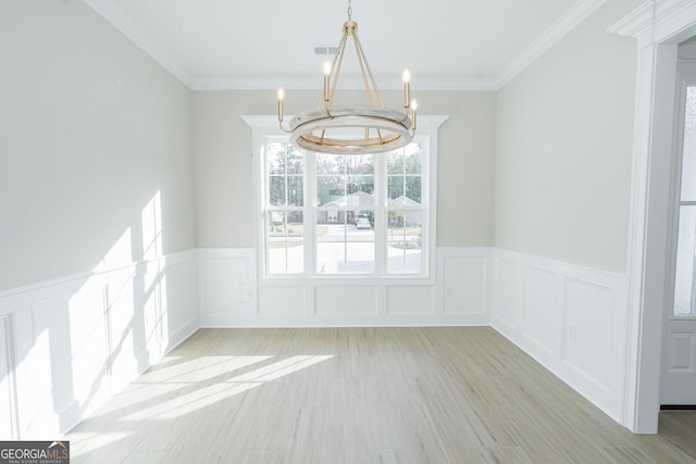 unfurnished dining area with light hardwood / wood-style flooring, crown molding, and a chandelier