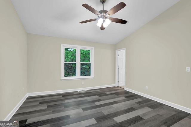 spare room with dark wood-type flooring, baseboards, a ceiling fan, and vaulted ceiling