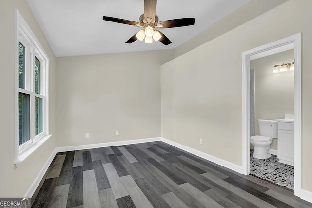 spare room with lofted ceiling, baseboards, a ceiling fan, and dark wood finished floors