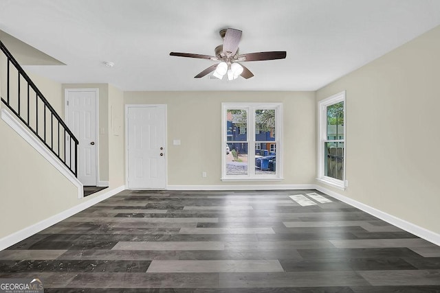 interior space with ceiling fan, stairway, wood finished floors, and baseboards