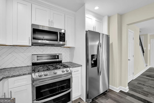 kitchen with stainless steel appliances, tasteful backsplash, white cabinetry, and dark wood finished floors