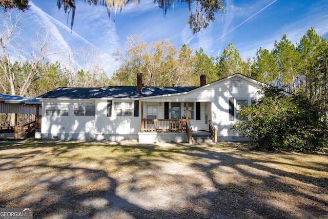 back of property with a yard and covered porch