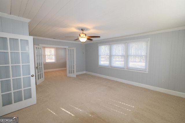 spare room with light carpet, french doors, ceiling fan, and ornamental molding