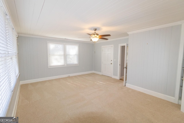 carpeted empty room with crown molding and ceiling fan