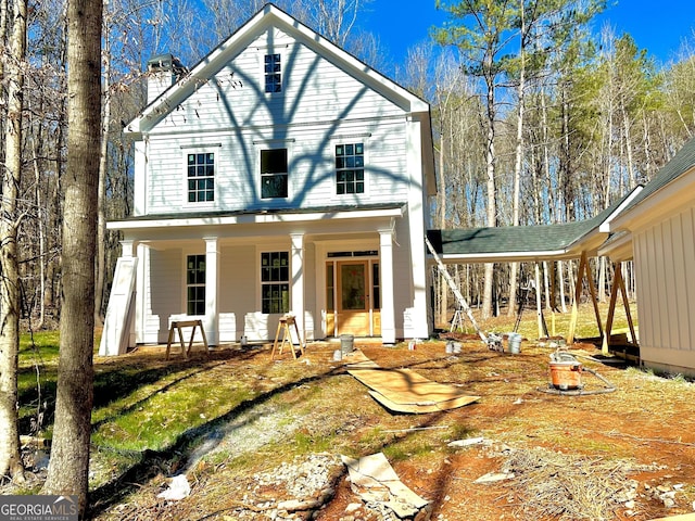 view of front of property with a chimney and a carport