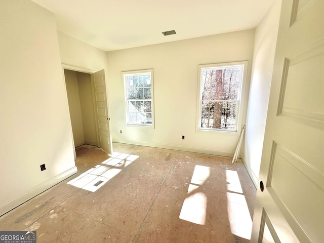 unfurnished bedroom featuring multiple windows and visible vents