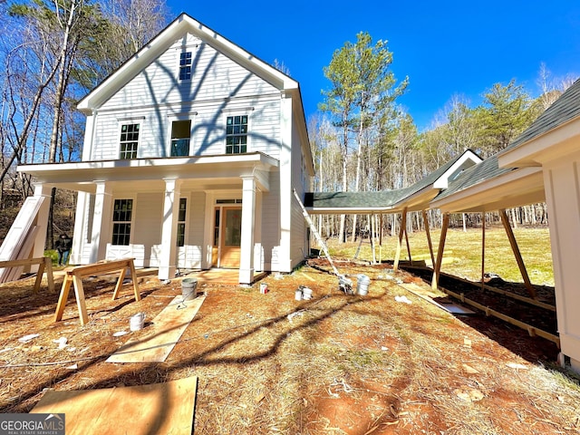 exterior space with driveway, a porch, and a detached carport