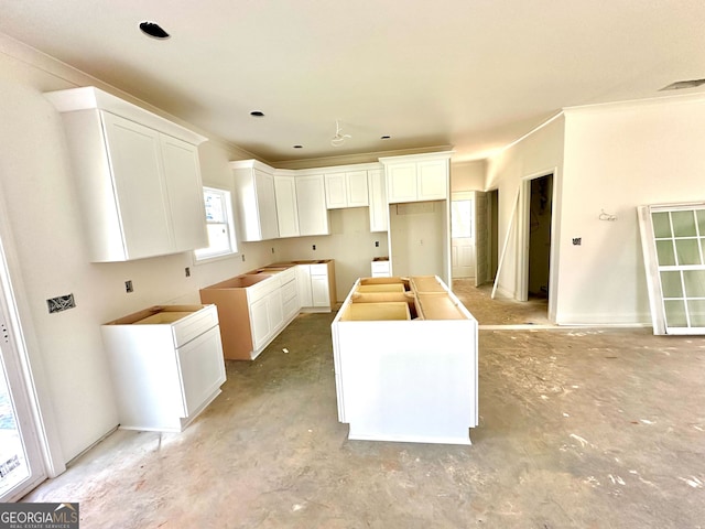 kitchen with a center island, visible vents, and white cabinets