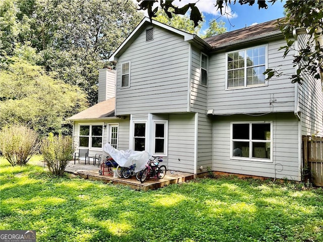 rear view of property with a lawn and a wooden deck