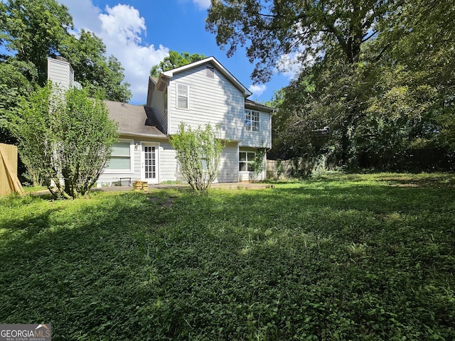 back of property featuring a yard