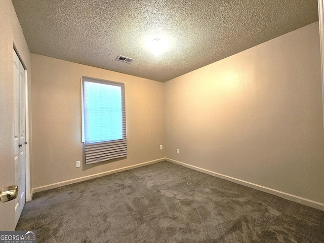 carpeted empty room with a textured ceiling