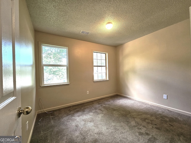 carpeted empty room with a textured ceiling