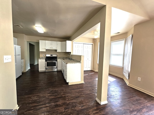 kitchen with sink, white refrigerator, stainless steel stove, white cabinetry, and dark hardwood / wood-style floors