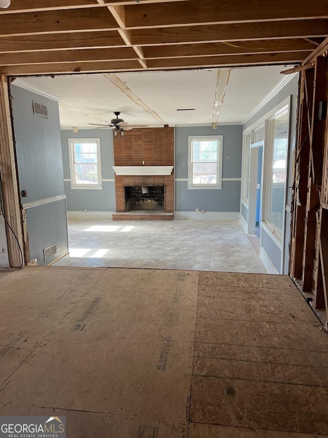 unfurnished living room with crown molding, a fireplace, and ceiling fan