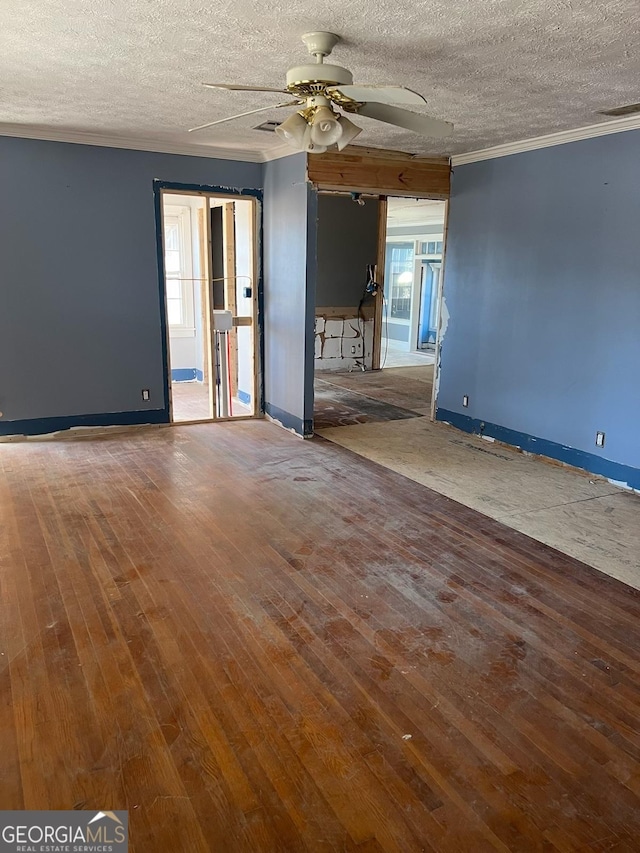 empty room featuring hardwood / wood-style flooring, ceiling fan, ornamental molding, and a textured ceiling