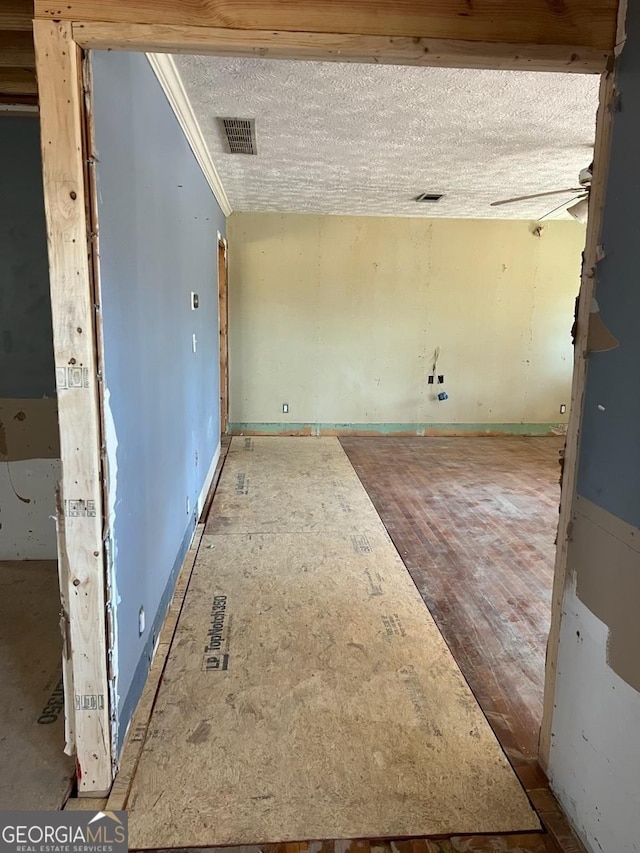 spare room featuring ceiling fan, crown molding, and a textured ceiling