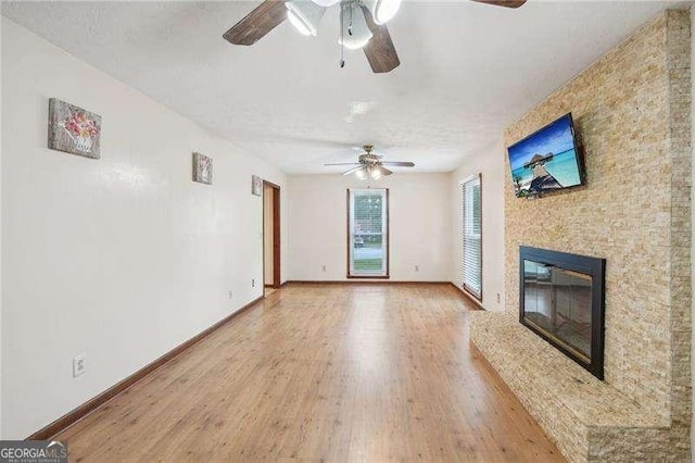 unfurnished living room with ceiling fan, wood-type flooring, and a high end fireplace