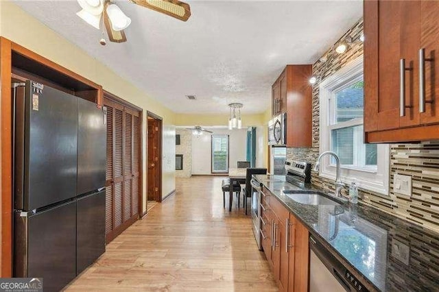 kitchen featuring appliances with stainless steel finishes, light hardwood / wood-style floors, a healthy amount of sunlight, and sink