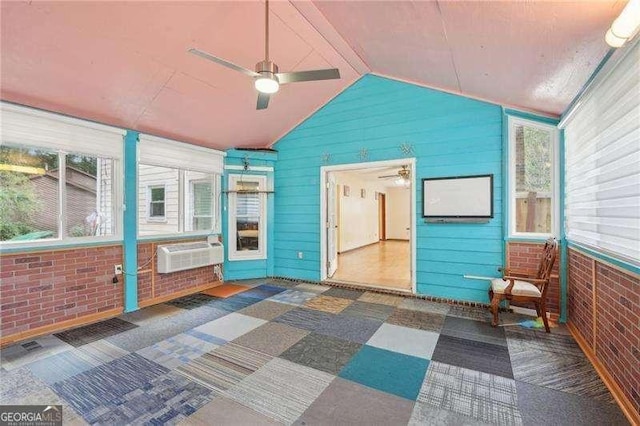 unfurnished sunroom with vaulted ceiling, an AC wall unit, and ceiling fan