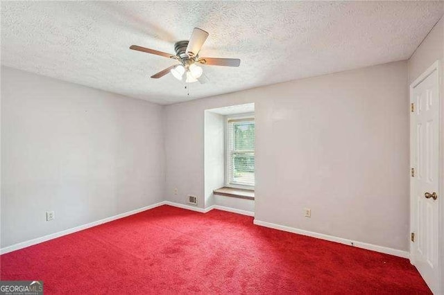 empty room with ceiling fan, carpet floors, and a textured ceiling