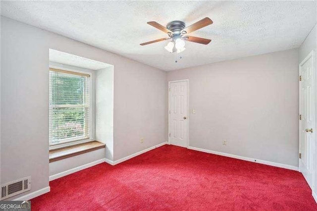 spare room featuring ceiling fan, carpet, and a textured ceiling