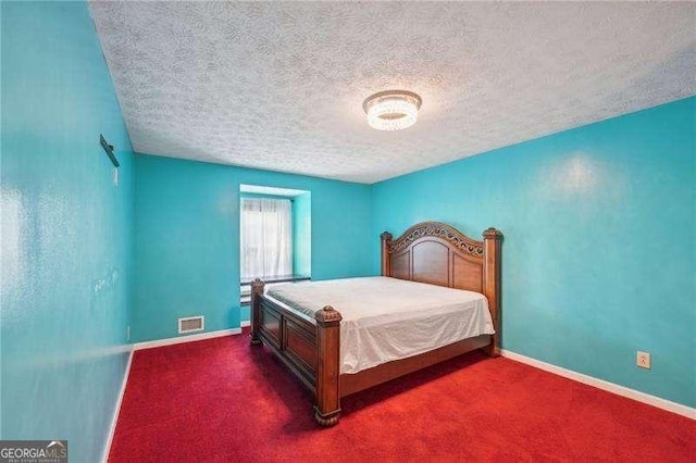 carpeted bedroom featuring a textured ceiling