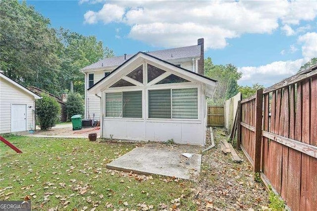 rear view of property featuring cooling unit, a patio area, and a yard