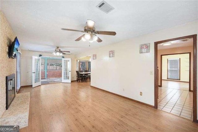 unfurnished living room with wood-type flooring and ceiling fan