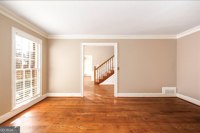 unfurnished room featuring wood-type flooring and ornamental molding